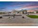 Beautiful single-story house with desert landscaping, updated exterior paint, and well-maintained lawn against the colorful sky at 460 W Chase St, San Tan Valley, AZ 85143