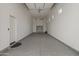 Empty, three car garage featuring sealed concrete floors, windows, and an automatic garage door at 460 W Chase St, San Tan Valley, AZ 85143