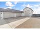 Large, detached garage with multiple doors, a spacious driveway, and a gravel pathway, enhancing curb appeal and functionality at 460 W Chase St, San Tan Valley, AZ 85143