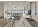 Open kitchen boasts a spacious island, modern cabinetry, and a view into the dining area and scenic outdoors at 460 W Chase St, San Tan Valley, AZ 85143
