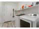 Laundry room with modern, front-loading washer and dryer, white cabinets, and ample storage shelves for household supplies at 460 W Chase St, San Tan Valley, AZ 85143