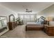 Spacious main bedroom featuring elegant furnishings, a ceiling fan, and natural light from shuttered windows at 460 W Chase St, San Tan Valley, AZ 85143