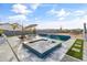 Backyard showcasing a sparkling pool with a built-in hot tub, surrounded by a paved patio and desert landscaping at 460 W Chase St, San Tan Valley, AZ 85143