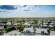An aerial shot displays a suburban neighborhood featuring green trees and well-maintained houses with white roofs at 462 N Bedford Ct, Chandler, AZ 85225