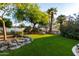 Expansive backyard featuring lush artificial turf, rock features, and mature landscaping with a covered gazebo at 462 N Bedford Ct, Chandler, AZ 85225