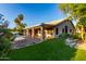 Back exterior of the house, with a covered patio, adjacent to a grassy lawn and a pool area at 462 N Bedford Ct, Chandler, AZ 85225