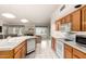 Bright kitchen with wood cabinets, white countertops, and view into the living room at 462 N Bedford Ct, Chandler, AZ 85225