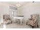 Bright formal living room with a piano, chandelier, and two sitting chairs in a well-lit space at 462 N Bedford Ct, Chandler, AZ 85225