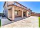 Backyard patio with travertine pavers, a covered area with a ceiling fan, and partial lawn at 550 E Zion Pl, Chandler, AZ 85249
