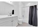 A clean bathroom featuring a single vanity, tub with shower, tiled floor, and black shower curtain at 550 E Zion Pl, Chandler, AZ 85249