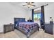 Well-lit bedroom includes a wood frame bed, dark curtains, and a cozy workspace with a desk and chair at 550 E Zion Pl, Chandler, AZ 85249