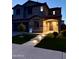 Inviting two-story home featuring a manicured lawn and an illuminated stone pathway leading to the front entrance at 550 E Zion Pl, Chandler, AZ 85249