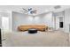 Open living room with gray carpet, large tan leather sectional, modern ceiling fan, and lots of space at 550 E Zion Pl, Chandler, AZ 85249