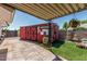 Charming backyard with a red storage shed, decorative bicycle, and low-maintenance artificial grass at 6247 E Albany St, Mesa, AZ 85205
