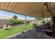 Inviting covered patio with wicker furniture overlooking a well-manicured lawn and garden at 6247 E Albany St, Mesa, AZ 85205