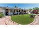 Charming backyard featuring a covered patio, solar panels, and artificial turf for low maintenance at 6247 E Albany St, Mesa, AZ 85205