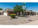 Corner lot single-story brick home featuring desert landscaping with green tree and shrubbery at 6247 E Albany St, Mesa, AZ 85205