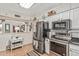 Kitchen features stainless steel appliances, white cabinetry, subway tile backsplash, and tile floors at 6247 E Albany St, Mesa, AZ 85205
