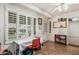 Bright sun room features white walls, windows with plantation shutters, and tile floors at 6247 E Albany St, Mesa, AZ 85205