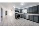 Bright kitchen features tile flooring, sleek gray cabinets, stainless steel appliances, and a modern backsplash at 6449 E Ellis St, Mesa, AZ 85205