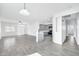 Open-concept living space with gray wood-look flooring and a modern kitchen in the background at 7207 W Alta Vista Rd, Laveen, AZ 85339