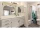 Well-lit bathroom boasts a white vanity, a large mirror, and a shower-tub combination at 7826 W Mcrae Way, Glendale, AZ 85308