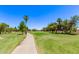 Serene golf course view with lush green fairways, mature trees, and a paved path for walking or golf carts at 7826 W Mcrae Way, Glendale, AZ 85308