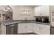 Well-lit kitchen featuring stainless steel dishwasher and sink with white cabinets at 7826 W Mcrae Way, Glendale, AZ 85308
