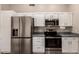 Kitchen featuring stainless steel appliances, ample white cabinetry, and modern fixtures at 7826 W Mcrae Way, Glendale, AZ 85308
