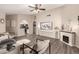 Open-concept living room with a fireplace, decorative accents, vinyl floors, and an archway to the kitchen at 7826 W Mcrae Way, Glendale, AZ 85308