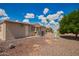 Backyard featuring a gravel landscape, mature trees, and the building's exterior, creating a low-maintenance outdoor space at 8103 E Southern #303 Ave, Mesa, AZ 85209