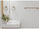 Modern bathroom featuring a chic vanity with gold fixtures, stylish mirror, and fresh greenery at 8403 E Fairmount Ave, Scottsdale, AZ 85251