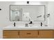 Bright bathroom featuring double sinks, sleek fixtures, and a large mirror at 8403 E Fairmount Ave, Scottsdale, AZ 85251