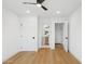 Bright bedroom with white walls, ceiling fan, and views to the bathroom; light-colored wood flooring throughout at 8403 E Fairmount Ave, Scottsdale, AZ 85251
