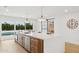 Modern kitchen island with bar seating, stainless steel sink, and sliding door at 8403 E Fairmount Ave, Scottsdale, AZ 85251