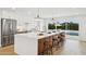 Modern kitchen features a large island with seating and stainless steel appliances with natural lighting at 8403 E Fairmount Ave, Scottsdale, AZ 85251