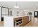 Contemporary kitchen island with white countertop, storage and view into the living room at 8403 E Fairmount Ave, Scottsdale, AZ 85251