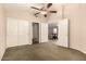 Well-lit bedroom featuring a ceiling fan, multiple doors, and closet space at 8628 W Maui Ln, Peoria, AZ 85381