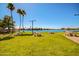Scenic view of waterfront park with picnic tables and lush green grass and palm trees at 8628 W Maui Ln, Peoria, AZ 85381