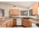 Functional kitchen with wood cabinets, tile counters, and modern appliances at 8628 W Maui Ln, Peoria, AZ 85381