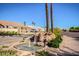 Charming neighborhood water feature with a rock fountain and lush greenery at 8628 W Maui Ln, Peoria, AZ 85381