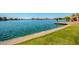 Personal stands on dock enjoying a tranquil view of a waterway bordered by green grass at 8628 W Maui Ln, Peoria, AZ 85381