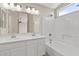 Bright bathroom featuring a dual sink, vanity, and shower-tub combo at 8750 W Granada Rd, Phoenix, AZ 85037