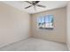 Bedroom featuring neutral carpet, paint, ceiling fan, and bright view from a large window at 8750 W Granada Rd, Phoenix, AZ 85037