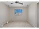 A bright bedroom with neutral carpet and walls features a window with a view of the sky at 8750 W Granada Rd, Phoenix, AZ 85037