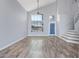 Open-concept living room featuring hardwood floors, tall windows, and a staircase to the upper level at 8750 W Granada Rd, Phoenix, AZ 85037