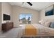Staged main bedroom with ceiling fan, sliding door to the balcony, and a comfy queen bed at 8750 W Granada Rd, Phoenix, AZ 85037