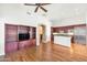 Open-concept living room features wood floors, ceiling fan, built-ins and seamless kitchen access at 8760 N 73Rd Way, Scottsdale, AZ 85258