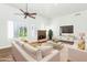 Bright living room with a fireplace, white sofa set and ceiling fan at 8760 N 73Rd Way, Scottsdale, AZ 85258