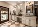Bright bathroom featuring duel sinks, tiled floor, and large mirrors and a TV at 9310 S Bala Dr, Tempe, AZ 85284